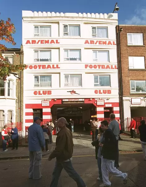 Arsenal fans walk outside the entrance to the West Stand Upper before the match