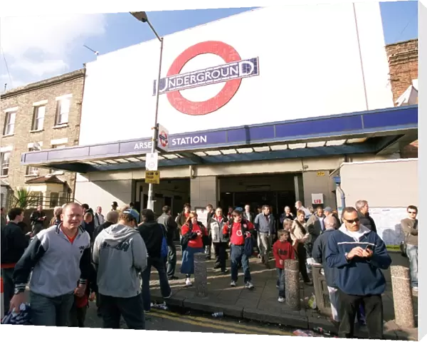 Arsenal fans walk outside Arsenal Tube Station before the match