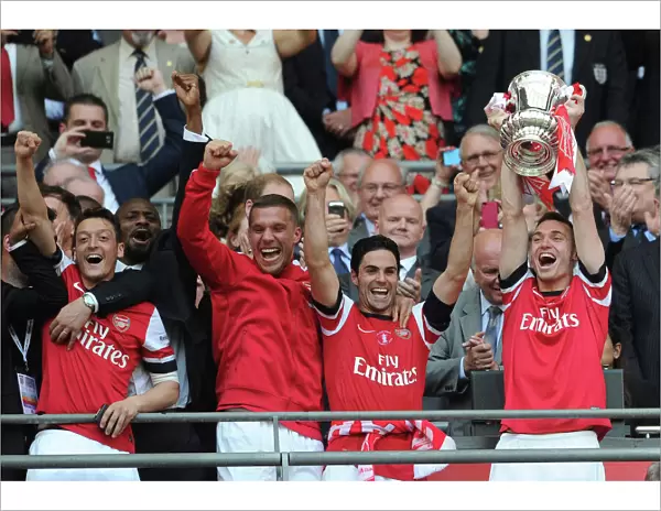 Arsenal FC: Mesut Ozil, Lukas Podolski, Mikel Arteta, and Thomas Vermaelen Lift the FA Cup after Arsenal's Victory over Hull City (2014)