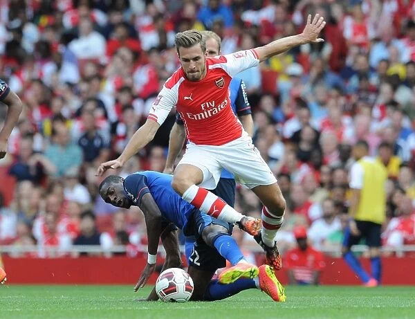 Arsenal's Aaron Ramsey Leaps Past AS Monaco's Geoffrey Kondogbia during the Emirates Cup Match