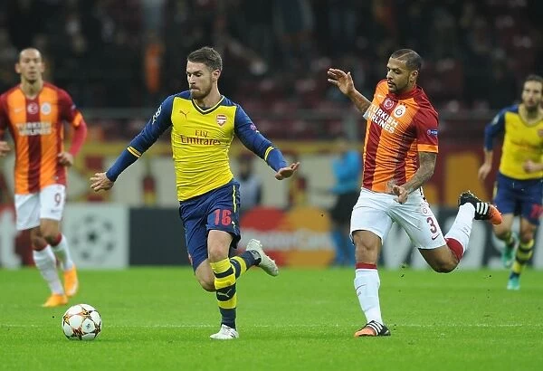 Arsenal's Aaron Ramsey Outmaneuvers Galatasaray's Felipe Melo in Champions League Clash