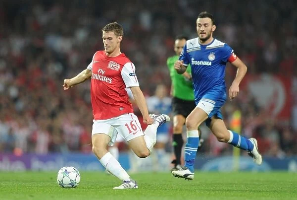 Arsenal's Aaron Ramsey Outmaneuvers Olympiacos Vassilis Torossidis during the 2011-12 Champions League Clash