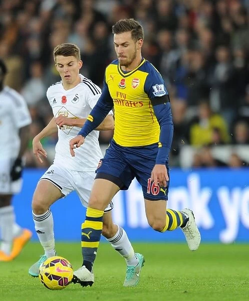 Arsenal's Aaron Ramsey Outmaneuvers Swansea's Tom Carroll