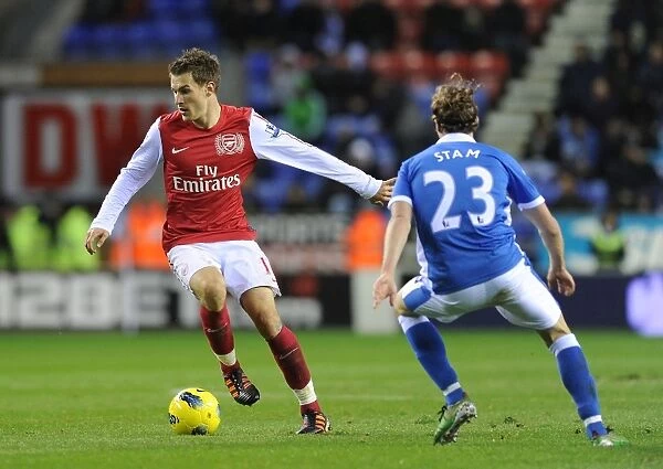 Arsenal's Aaron Ramsey Outmaneuvers Wigan's Ronnie Stam in Premier League Clash (December 2011)