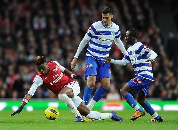 Arsenal's Alex Song Breaks Through QPR Defenders During Premier League Clash