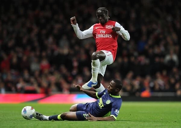 Arsenal's Bacary Sagna Jumps Over Wigan's Figueroa during the 2011-12 Premier League Match