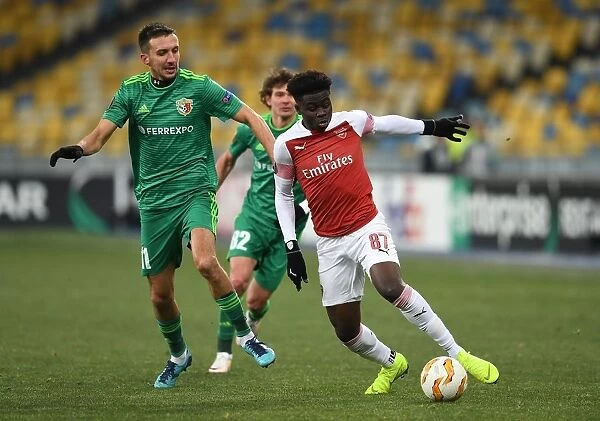 Arsenal's Bukayo Saka Clashes with Vyacheslav Sharpar of Vorskla in Europa League Match
