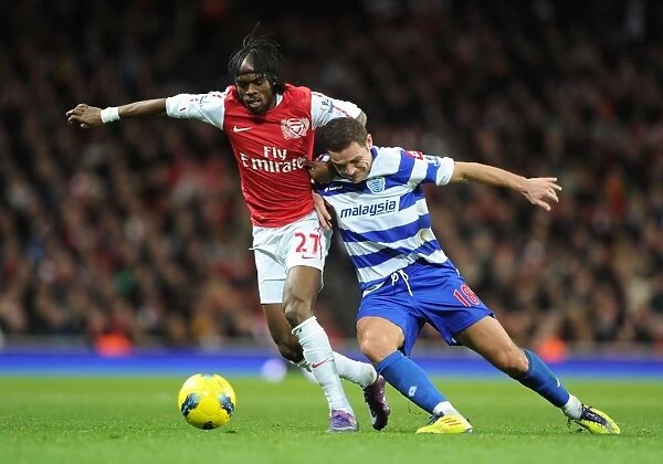 Arsenal's Gervinho Faces Off Against QPR's Luke Young during the 2011-12 Premier League Match