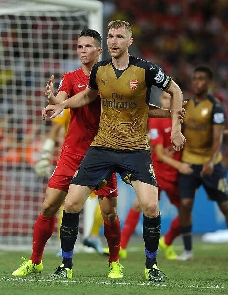 Arsenal's Per Mertesacker Fends Off Opponent in Barclays Asia Trophy Clash vs Singapore (July 15, 2015)