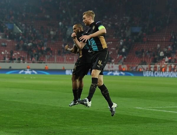 Arsenal's Per Mertesacker and Theo Walcott Celebrate Champions League Victory over Olympiacos