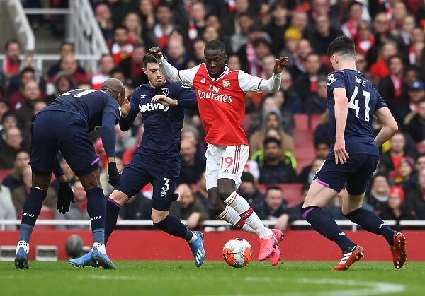 Arsenal's Nicolas Pepe Clashes with West Ham's Rice and Cresswell during the Premier League Match