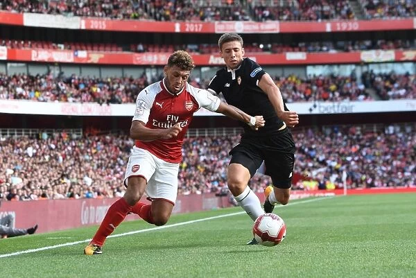 Arsenal's Oxlade-Chamberlain Clashes with Sevilla's Corchia in Emirates Cup Battle