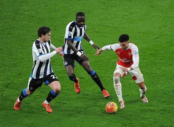 Arsenal's Oxlade-Chamberlain Stands Firm Against Newcastle's Janmaat and Sissoko