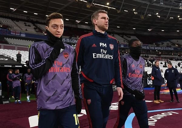 Arsenal's Ozil and Mertesacker Lead Team Out Against West Ham in Premier League Clash