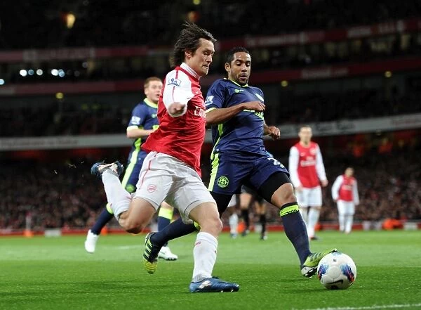 Arsenal's Rosicky Faces Off Against Wigan's Beausejour in Intense Premier League Clash