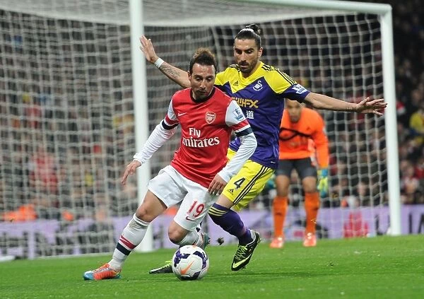 Arsenal's Santi Cazorla Fends Off Swansea's Chico Flores in Premier League Clash