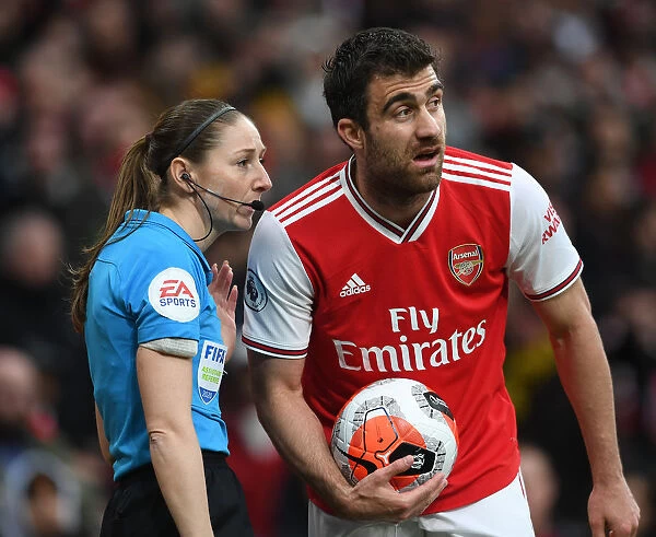 Arsenal's Sokratis Engages in Conversation with Assistant Referee Sian Massey-Ellis during Arsenal vs. West Ham Match
