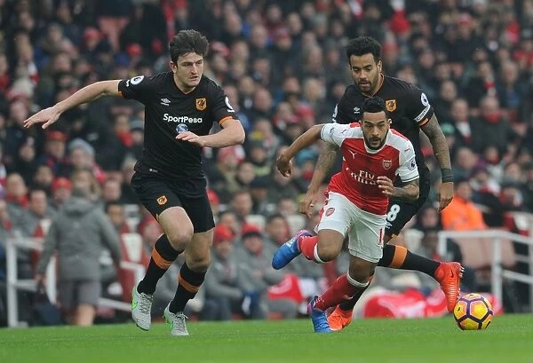 Arsenal's Theo Walcott Clashes with Hull City's Maguire and Huddlestone during Premier League Match