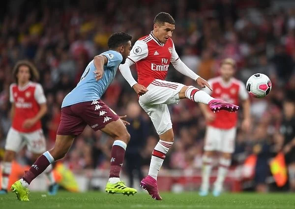 Arsenal's Torreira Fends Off Aston Villa's Taylor Amidst Premier League Battle