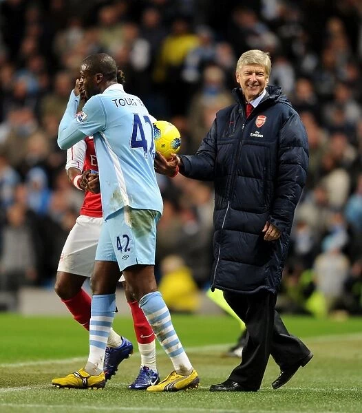 Arsene Wenger and Yaya Toure Share a Light-Hearted Moment Amidst Manchester City vs. Arsenal Rivalry (2011-12)
