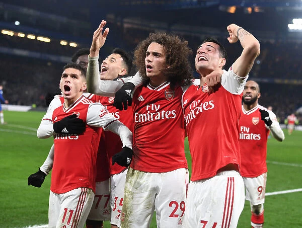 Celebrating Victory: Torreira, Guendouzi, and Xhaka Rejoice After Arsenal's Goal vs. Chelsea (Premier League 2019-20)