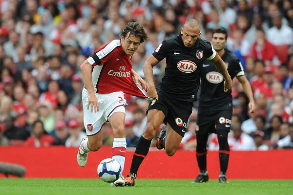Intense Clash: Rosicky vs. Heitinga in Arsenal's 2009 Emirates Cup Match Against Athletico Madrid (2:1)
