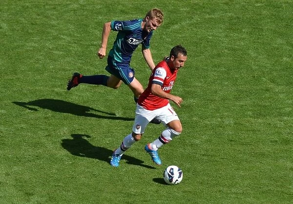 LONDON, ENGLAND - AUGUST 18: Santi Cazorla of Arsenal takes on Seb Larsson of Sunderland during the Barclays Premier League match between Arsenal and Sunderland at Emirates Stadium on August 18, 2012 in London, England. : Arsenal Football