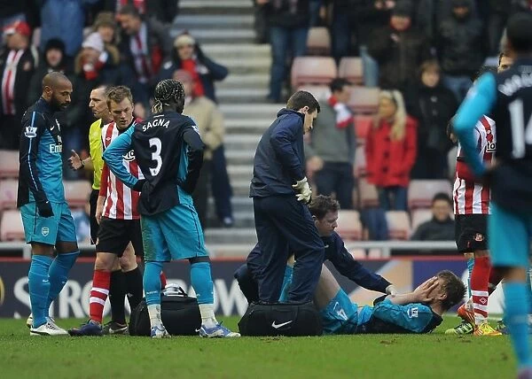 Per Mertesacker Receives Treatment from Physio Colin Lewin during Arsenal's 1:2 Win against Sunderland