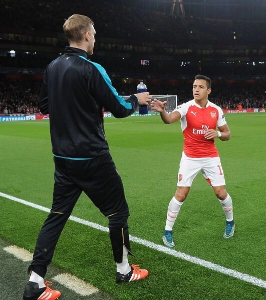Mertesacker's Support: Alexis Sanchez Receives Water Bottle from TeamMate During Arsenal vs. Olympiacos (2015 / 16) UEFA Champions League