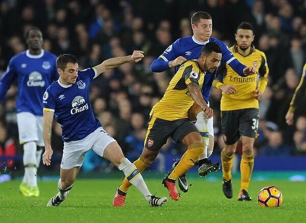 Theo Walcott Clashes with Everton's Leighton Baines and Ross Barkley during the Intense Everton vs Arsenal Premier League Match, 2016-17