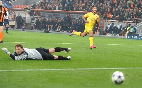 Theo Walcott shoots past Shakhtar goalkeeper Andriy Pyatov to score the Arsenal goal