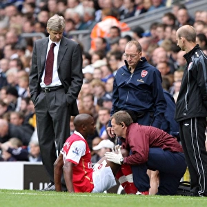 Arsenal manager Arsene Wenger looks on as injured captain William Gallas is treated by Gary Lewin