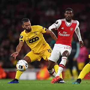 Arsenal Under Pressure: Ainsley Maitland-Niles Faces Off Against Mehdi Carcela in Europa League Clash