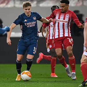 Arsenal's Martin Odegaard Clashes with Olympiacos Kenny Lala in UEFA Europa League Match Amidst Empty Stands