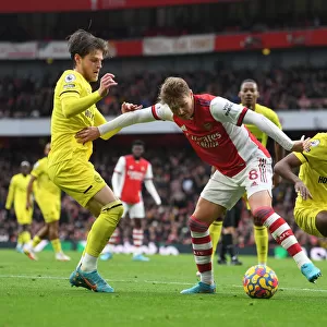 Arsenal's Martin Odegaard Faces Off Against Brentford's Mathias Jensen and Rico Henry in Intense Premier League Showdown