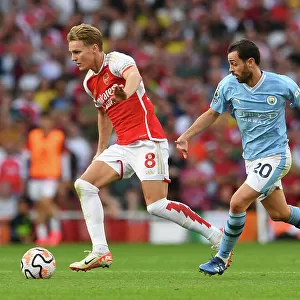 Arsenal's Martin Odegaard Faces Pressure from Manchester City's Bernardo Silva in 2023-24 Premier League Clash