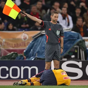 The linesman stands over injured Robin van Persie (Arsenal)