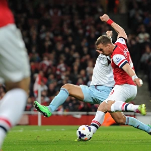 Lukas Podolski scores his and Arsenals 1st goal under pressure from Winston Reid (West Ham)