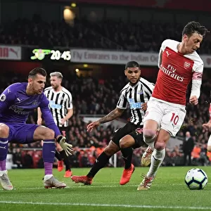 Mesut Ozil Faces Intense Pressure from Newcastle's DeAndre Yedlin and Martin Dubravka during Arsenal vs Newcastle Premier League Match