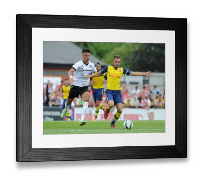 Framed Print : Clash of the Titans: Aaron Ramsey vs Lee Angol - Arsenal's Pre-Season Showdown with Boreham Wood