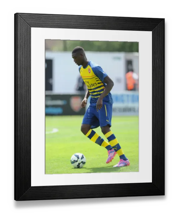 Framed Print : Yaya Sanogo (Arsenal) warms up before the match. Boreham Wood 0: 2 Arsenal. Pre Season Friendly