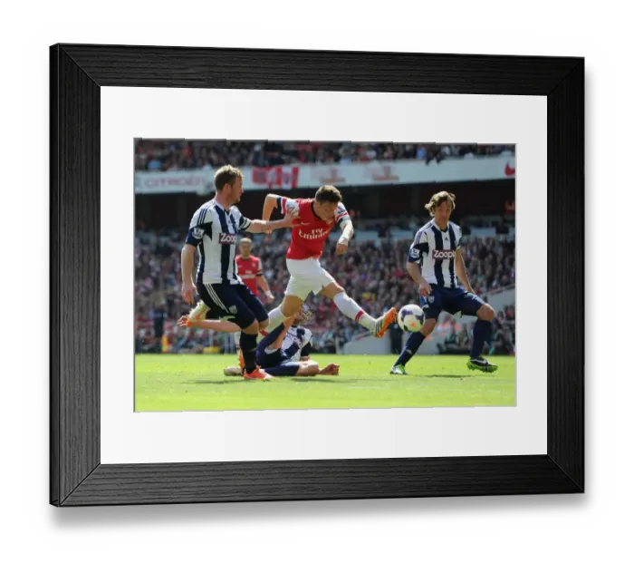 Framed Print : Mesut Ozil Faces Off Against Chris Brunt and Diego Lugano: Arsenal vs West Bromwich Albion, Premier League 2013-14