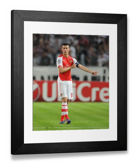 Framed Print : Laurent Koscielny Leads Arsenal in UEFA Champions League Play-Offs against Besiktas (2014) Framed Print : Laurent Koscielny Leads Arsenal in UEFA Champions League Play-Offs against Besiktas (2014)