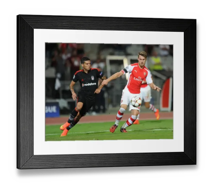 Framed Print : Arsenal's Aaron Ramsey Faces Off Against Besiktas Ramon Motta in UEFA Champions League Qualifier