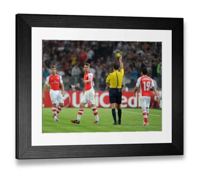 Framed Print : Aaron Ramsey Yellow Carded by Milorad Mazic in Arsenal's UEFA Champions League Clash against Besiktas (2014) Framed Print : Aaron Ramsey Yellow Carded by Milorad Mazic in Arsenal's UEFA Champions League Clash against Besiktas (2014)