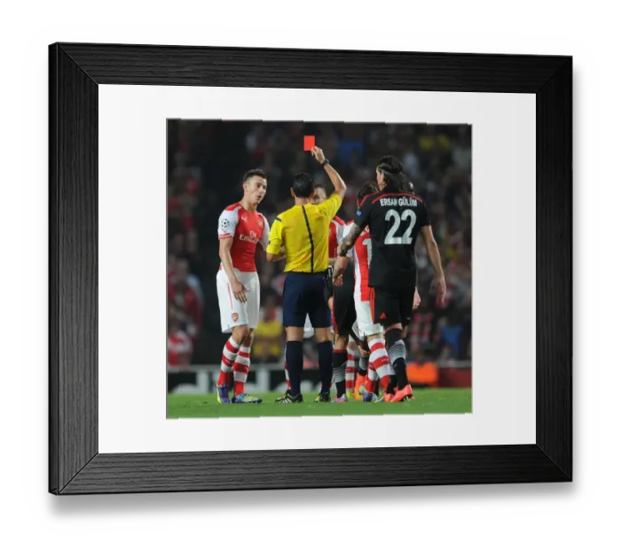 Framed Print : Arsenal's Debuchy Dismissed: Koscielny Looks On as Proenca Shows Red in Arsenal v Besiktas Clash Framed Print : Arsenal's Debuchy Dismissed: Koscielny Looks On as Proenca Shows Red in Arsenal v Besiktas Clash