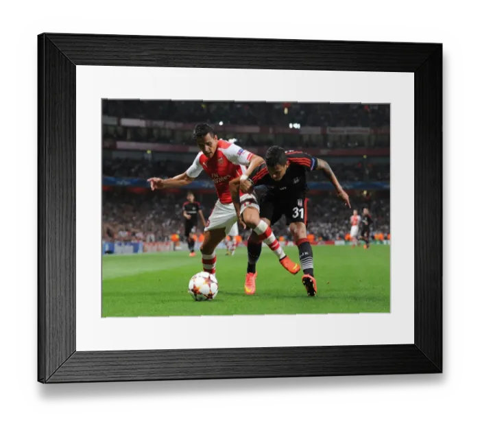 Framed Print : Arsenal's Alexis Sanchez Tackles Besiktas Ramon Motta in Champions League Showdown