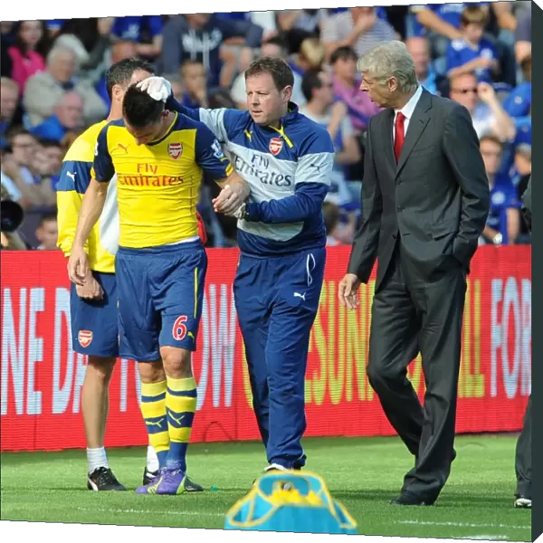 Laurent Koscielny (Arsenal) with Physio Colin Lewin and Arsene Wenger the Arsenal Manager