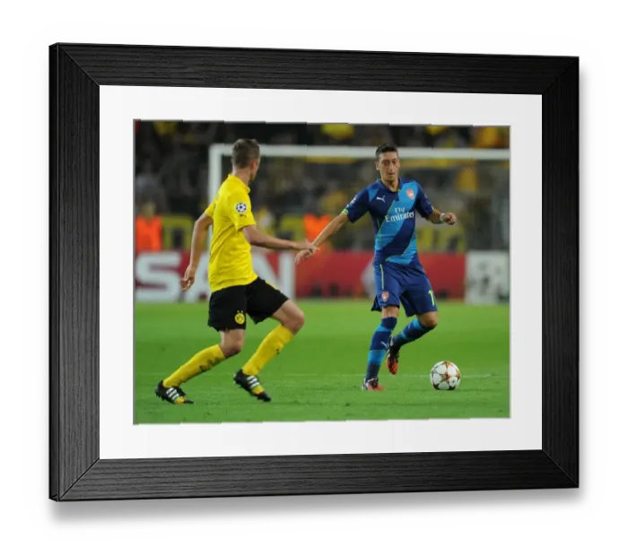 Framed Print : Mesut Ozil vs. Sven Bender: Intense Battle in Borussia Dortmund vs. Arsenal UEFA Champions League Clash