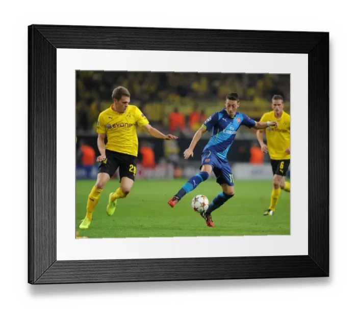 Framed Print : Mesut Ozil vs. Matthias Ginter: Intense Battle in Borussia Dortmund vs. Arsenal UEFA Champions League Clash